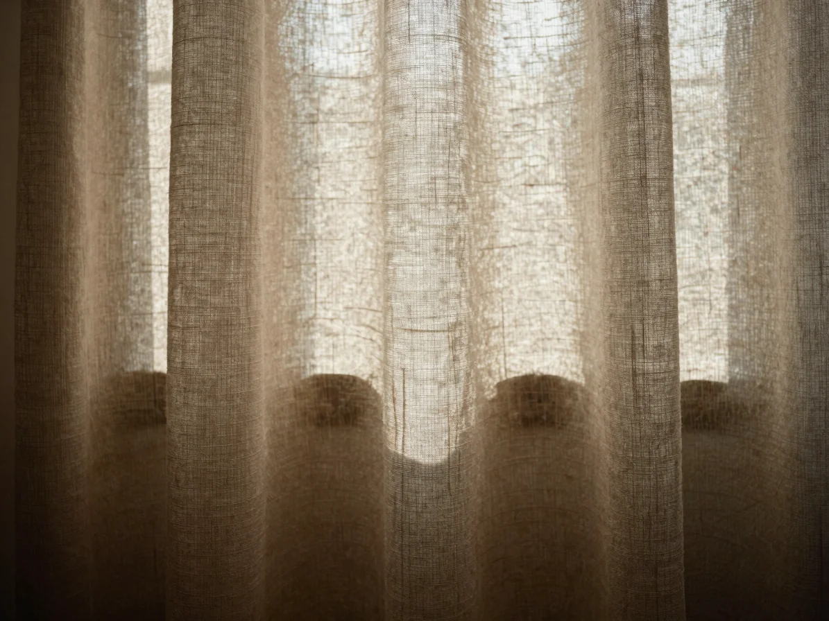 Close-up of sun-washed linen textile, soft morning light, texture